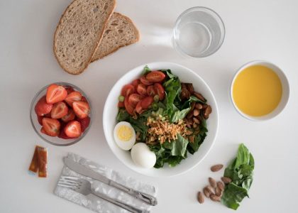 Top view of a nutritious breakfast with salad, eggs, bread, and juice, perfect for a healthy start.